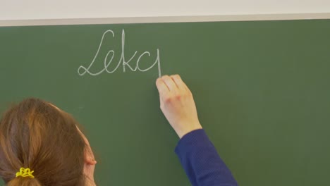 Female-teacher-writing-on-a-chalkboard