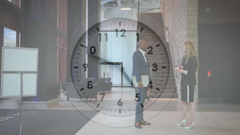 Animation-of-clock-moving-over-diverse-colleagues-talking-at-work