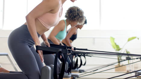 Three-women-practicing-pilates-on-reformer-machines