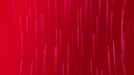 Animation-of-glowing-light-trails-moving-over-red-background