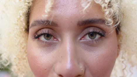 Close-up-of-a-young-biracial-woman-with-curly-blonde-hair-and-a-nose-ring