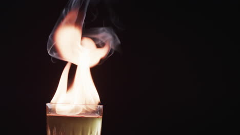 A-flaming-cocktail-ignites-with-dramatic-effect,-with-copy-space