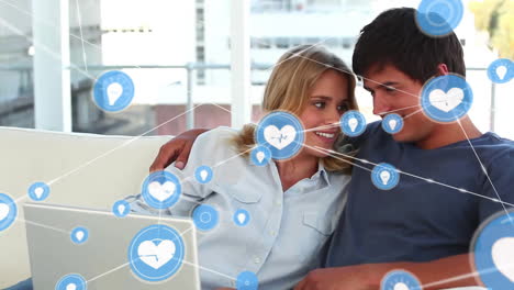 Animation-of-network-of-connections-with-icons-over-caucasian-couple-using-laptop
