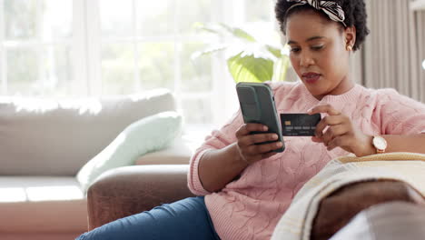 African-American-woman-is-shopping-online-with-a-credit-card-with-copy-space-at-home