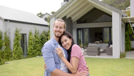 A-young-biracial-couple-embraces-lovingly-in-their-backyard