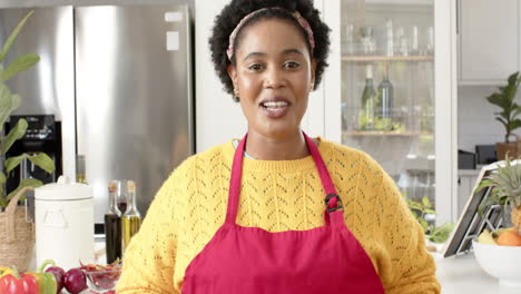 Middle-aged-African-American-woman-in-yellow-sweater-and-red-apron