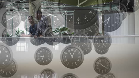 Animation-of-moving-clocks-over-diverse-colleagues-talking-in-office