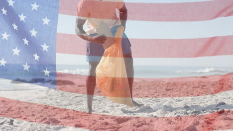 Animation-of-flag-of-usa-over-african-american-man-recycling-on-beach-in-summer
