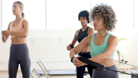 Tres-Mujeres-Están-Entrenando-En-Un-Brillante-Estudio-De-Yoga-Pilates