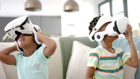 African-American-sister-and-brother-are-engaged-with-virtual-reality-headsets-at-home