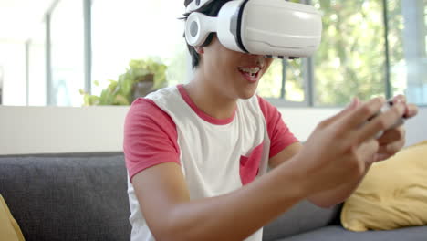 Asian-college-student-in-VR-headset-plays-game-with-controllers