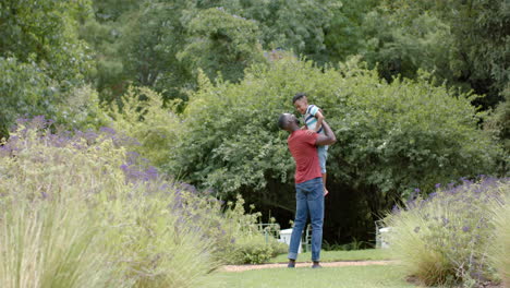 African-American-father-holds-his-son-in-a-loving-embrace-outdoors-at-home-with-copy-space