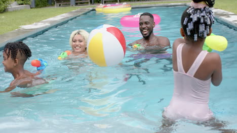 Familia-Feliz-De-Un-Hombre-Afroamericano-Y-Una-Joven-Birracial-Chapoteando-En-Una-Piscina-Con-Dos-Niños