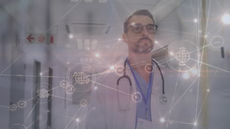 Animation-of-network-of-connections-with-icons-over-caucasian-male-doctor-at-hospital