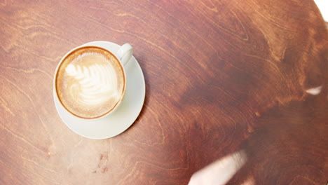 A-cup-of-coffee-with-latte-art-sits-on-a-wooden-table-in-a-cafe-with-copy-space