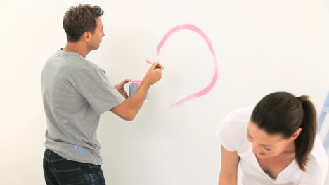 Young-couple-painting-a-wall-together