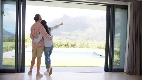 A-diverse-couple-is-admiring-the-view-from-their-home,-copy-space