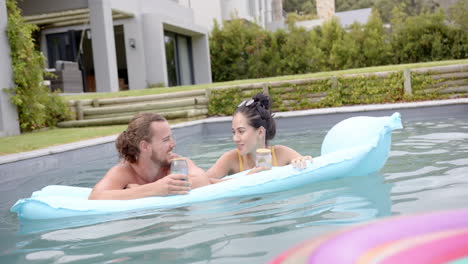 Una-Joven-Pareja-Caucásica-Se-Relaja-En-Una-Piscina-Con-Bebidas