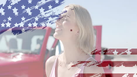 Animation-of-flag-of-usa-over-happy-caucasian-woman-by-car-on-beach