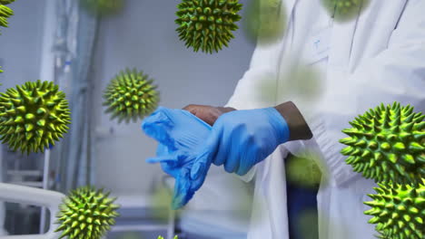 Animation-of-virus-cells-over-african-american-male-doctor-wearing-medical-gloves