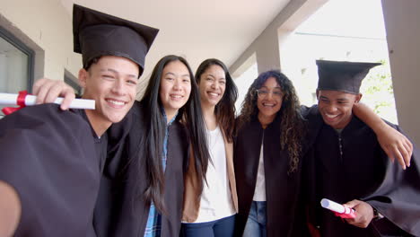 Diverse-group-of-teenagers-laugh-while-looking-at-a-smartphone-on-school-stairs-in-high-school