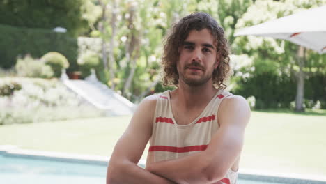 Young-Caucasian-man-with-curly-hair-smiles,-arms-crossed-in-a-relaxed-pose