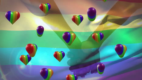 Animation-Von-Regenbogenherzen-Und-Einer-Flagge-über-Menschen,-Die-Sich-An-Den-Händen-Halten