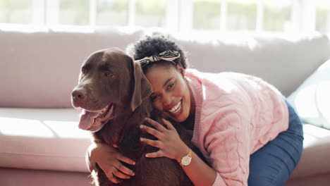 African-American-woman-embraces-a-brown-labrador-dog-on-a-sofa-at-home