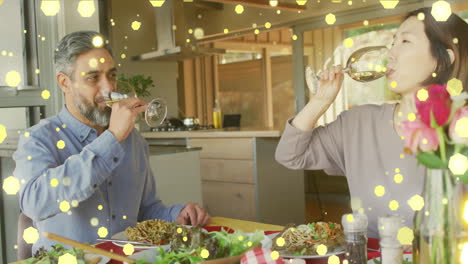 Animation-of-light-spots-over-diverse-couple-eating-dinner-and-drinking-wine-at-home