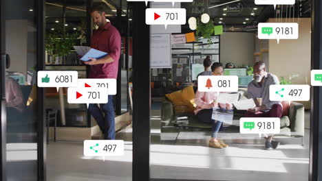 Animation-of-social-media-notifications-over-diverse-colleagues-talking-at-casual-office