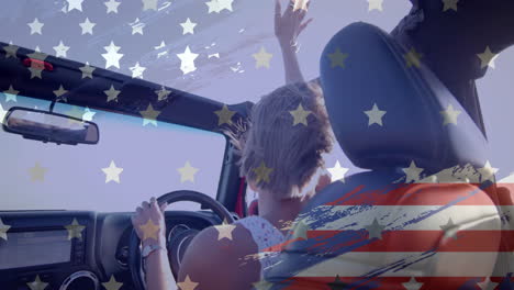 Animation-of-flag-of-usa-over-caucasian-woman-driving-car-on-beach