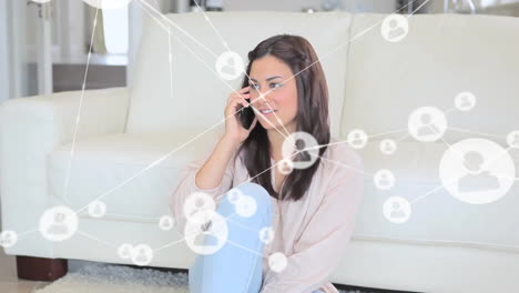 Animation-of-network-of-connections-with-icons-over-caucasian-woman-talking-on-smartphone