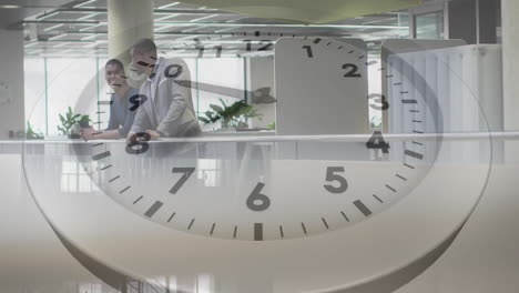 Animation-of-clock-moving-over-diverse-colleagues-discussing-work