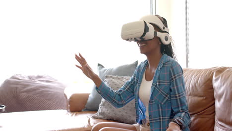 African-American-young-woman-wearing-virtual-reality-headset,-reaching-out