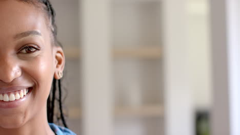 African-American-young-woman-smiling,-standing-indoors