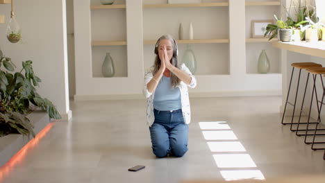 Mujer-Caucásica-Con-Pelo-Gris-Practicando-Yoga-En-Casa.