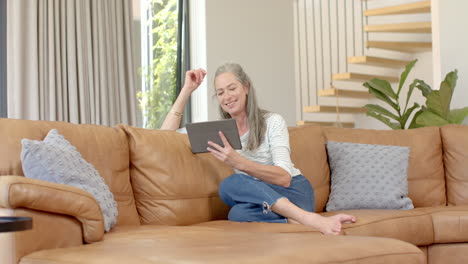 Kaukasische-Reife-Frau-Sitzt-Auf-Dem-Sofa-Und-Hält-Ein-Tablet