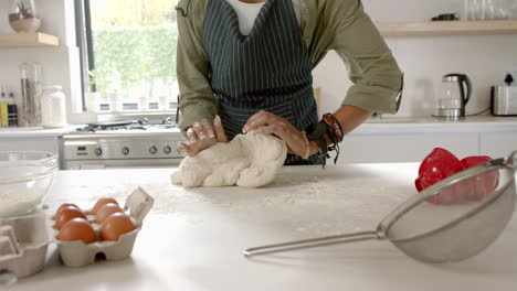 African-American-young-woman-kneading-dough-in-kitchen