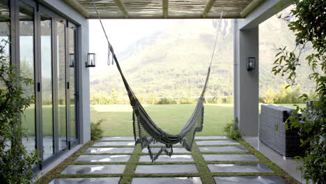 A-hammock-hanging-between-two-pillars-on-patio-with-mountains-in-background