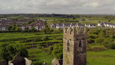 Claregalway-Klosterturmruinen-Mit-Fluss-Clare-Trennt-Leeres-Land-Von-Häusern