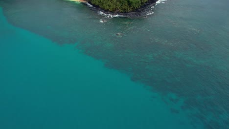 Tilt-up-reveal-shot-of-Island-landscape-surrounded-by-lush-jungle-in-São-Tomé-e-Principe-Island