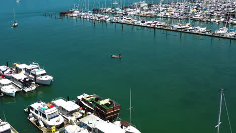 Aerial-view-toward-small-boat-set-to-leave-the-Sausalito-marina,-in-sunny-USA