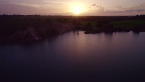 Drone-flying-over-a-lake-revealing-the-sunset