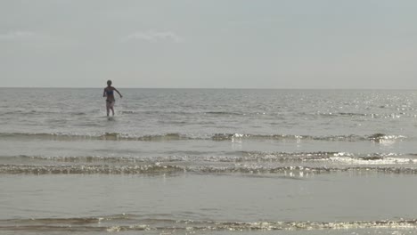 Beautiful-slow-motion,-splashing,-girl-running-towards-beach-shoreline