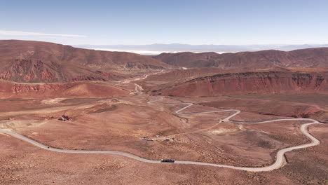 Drone-Aéreo-Ascendente-Con-Vista-A-La-Ruta-52-Sinuosa-Y-Curvada-A-Través-De-Las-Montañas-Del-Desierto-En-La-Provincia-De-Jujuy,-Argentina