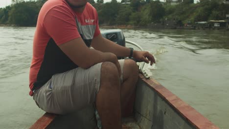 Man-sits-in-a-boat-navigating-the-river-in-Florencia,-Colombia