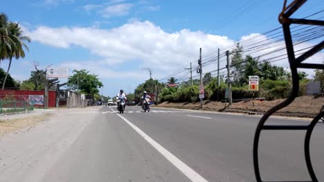 Philippines,-Dumaguete:-The-video-captures-traffic-from-a-low-angle-near-the-road,-following-our-tuk-tuk-through-the-bustling-streets