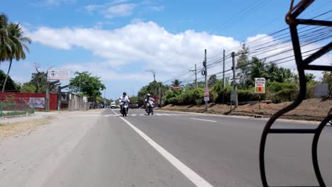 Filipinas,-Dumaguete:-El-Vídeo-Captura-El-Tráfico-Desde-Un-ángulo-Bajo-Cerca-De-La-Carretera,-Siguiendo-A-Nuestro-Tuk-tuk-Por-Las-Bulliciosas-Calles.