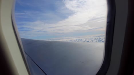 Impresionante-Cielo-A-Través-De-La-Ventana-Del-Avión-Sobre-Un-Lecho-De-Nubes-Con-Reflejo-Del-Sol