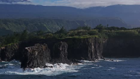 Wide-aerial-pan-of-waves-washing-over-cliffs-by-North-Shore-of-Maui,-Hawaii